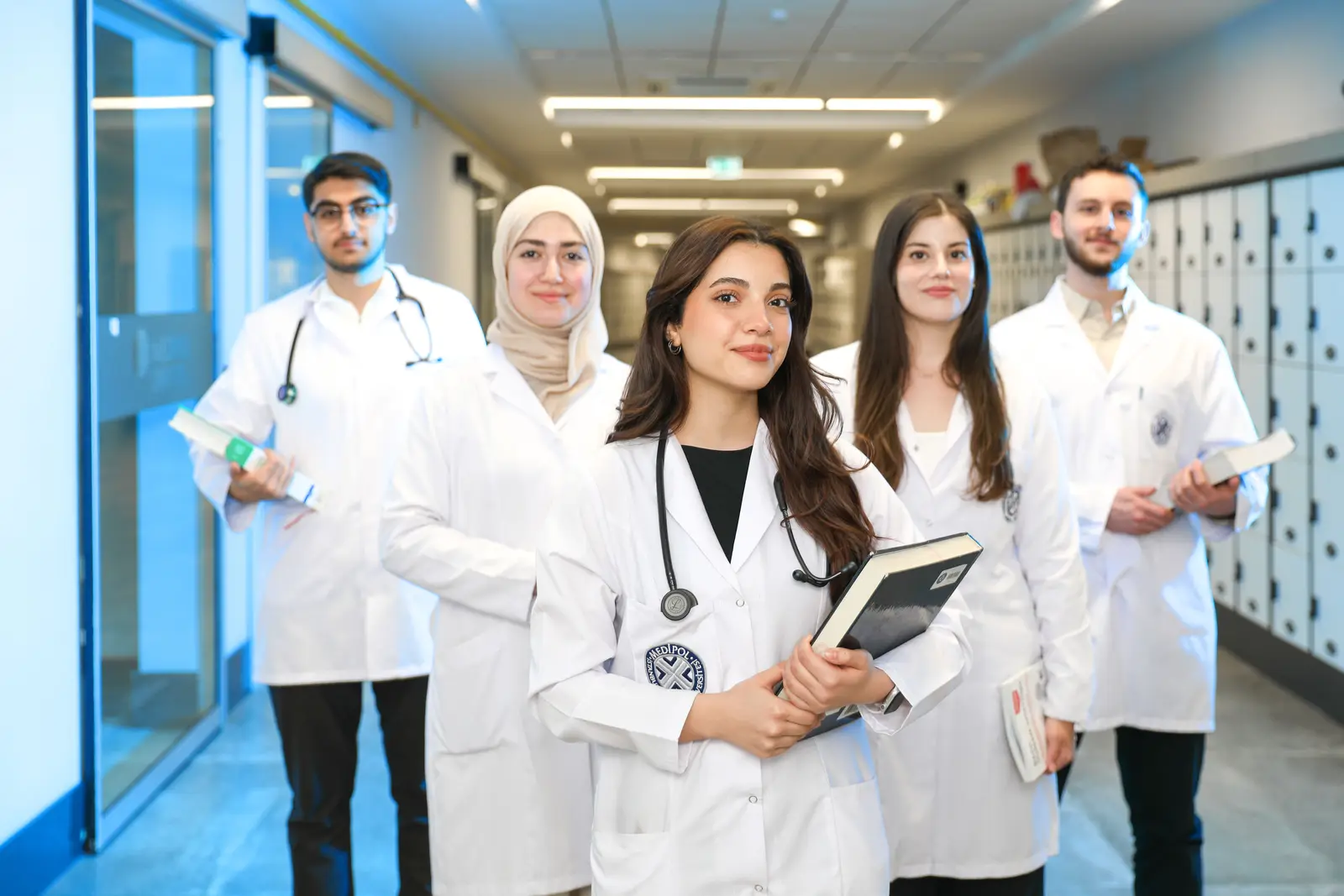 Estudiantes de Medicina con bata en un pasillo