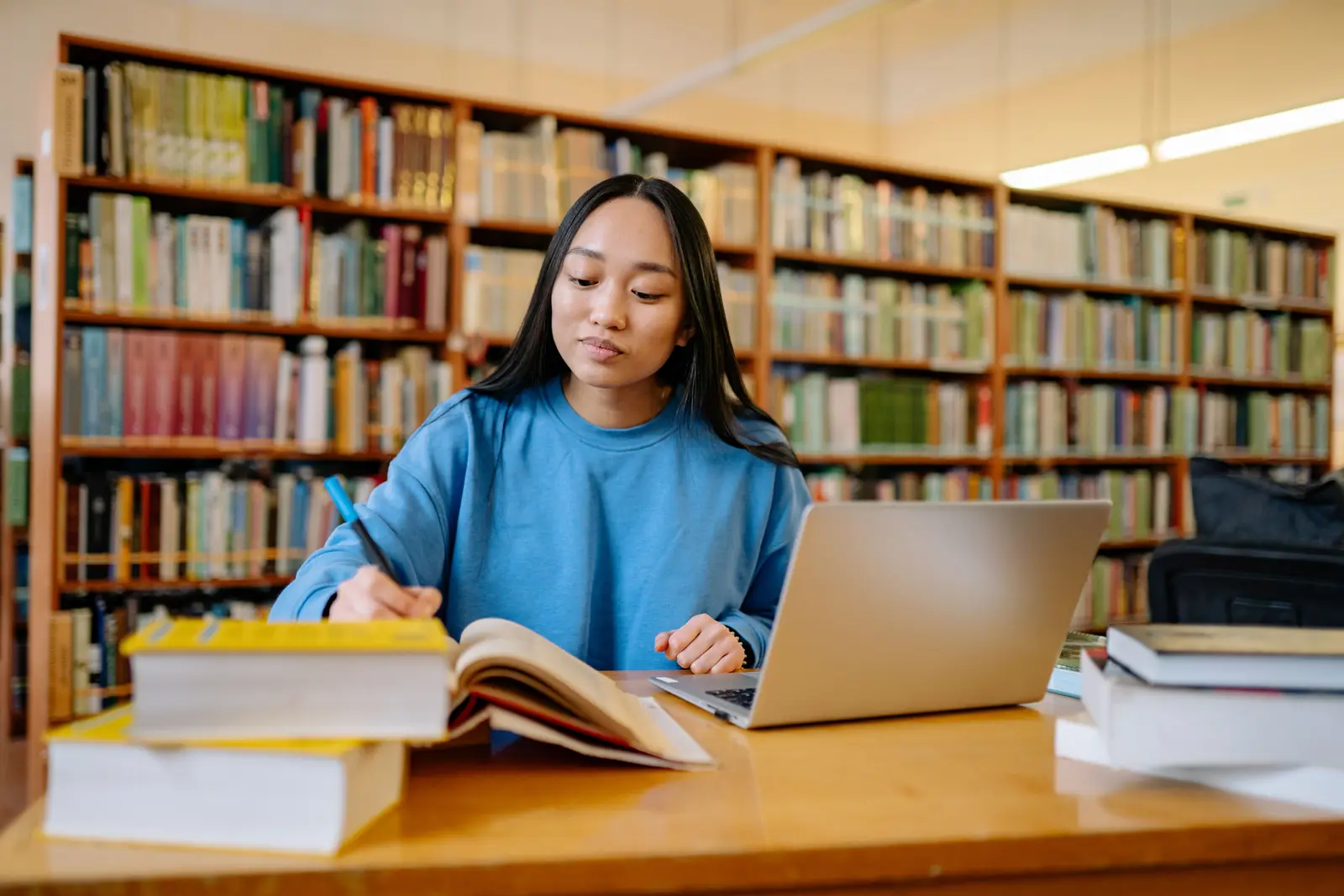 Estudiante repasando con apuntes y portátil